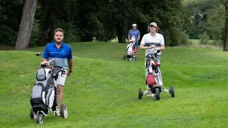 joueur-de-golf-qui-marche-avec-leurs-sacs-sur-le-terrain-de-golf