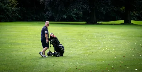 joueur-de-golf-qui-marche-sur-le-terrain-avec-son-sac