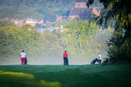 terrain-de-golf-avec-de-la-brume-et-des-joueurs-de-dos