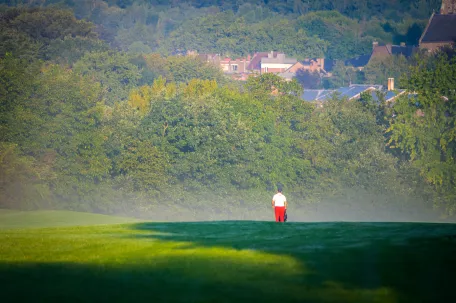 terrain-de-golf-avec-de-la-brume-et-des-joueurs-de-dos