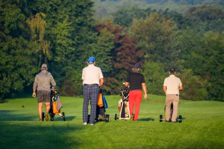 joueurs-de-golf-de-dos-qui-marche-sur-un-terrain